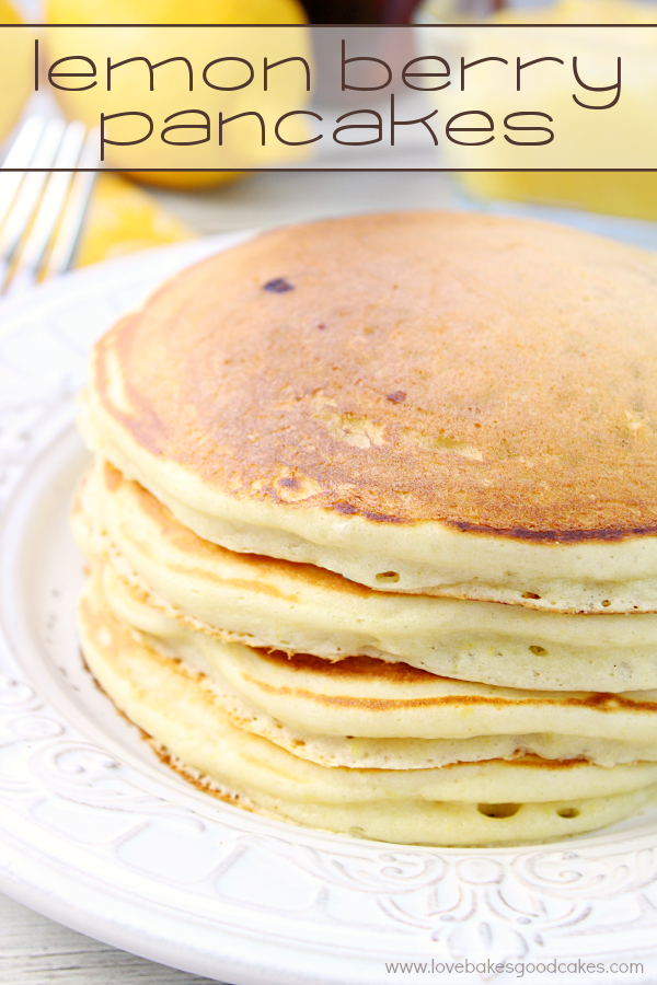 Lemon Berry Pancakes stacked on a white plate with lemons.