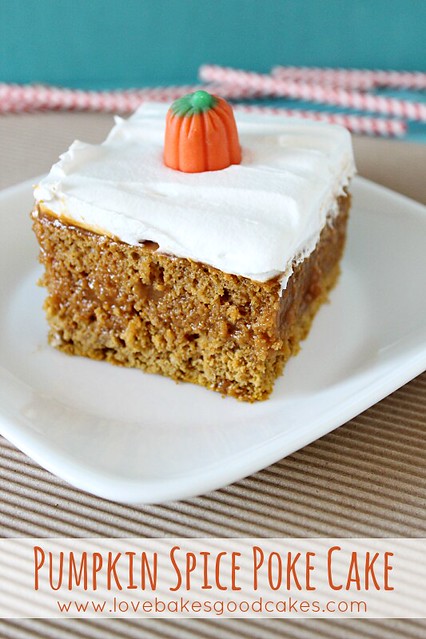 Pumpkin Spice Poke Cake on a white plate with a candy pumpkin on top.