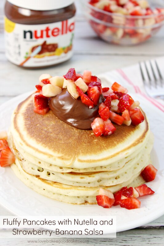 Fluffy Pancakes stacked up on a plate with Nutella and Strawberry-Banana Salsa. 