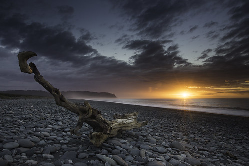 sunset sea newzealand sun seascape beach clouds pebbles stick okarito