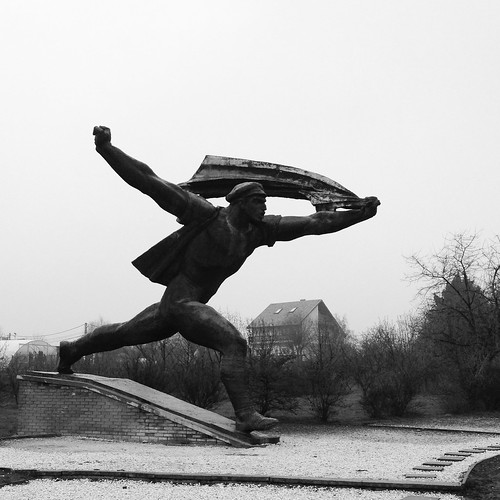 Sculpture of a man running with arms spread wide like wings.