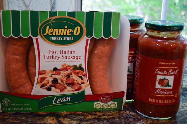 A package of Sausage and cans of marinara sauce.