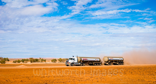 road red truck moving track desert transport large fast dry australia huge vehicle outback dust southaustralia plain arid tanker roadtrain cooberpedy semitrailer gibber oodnadatta bdouble primemover semitrailier
