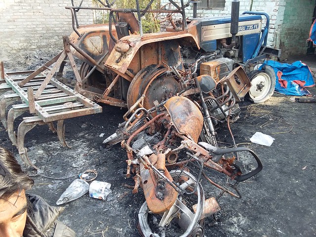 Burnt motorcycle and tractor in village Azizpur.