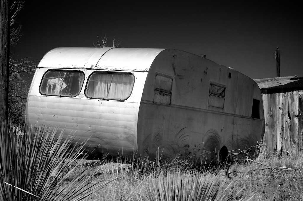Rustic abandoned broken down trailer in the southwest with a bright blue sky, photography art, for home and office décor
