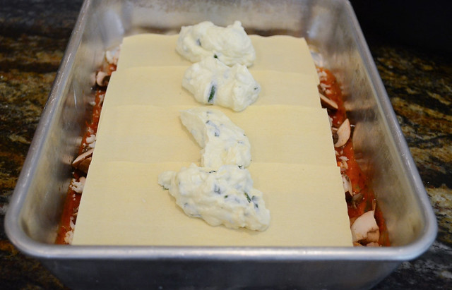 More Lasagna sheets and ricotta are placed on top of the marinara sauce.
