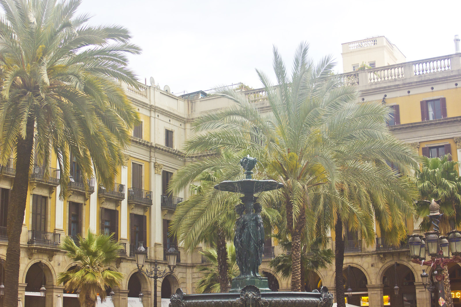 Barcelona pretty architecture exterior building gold peach white blue tiling tiles palm trees fountain