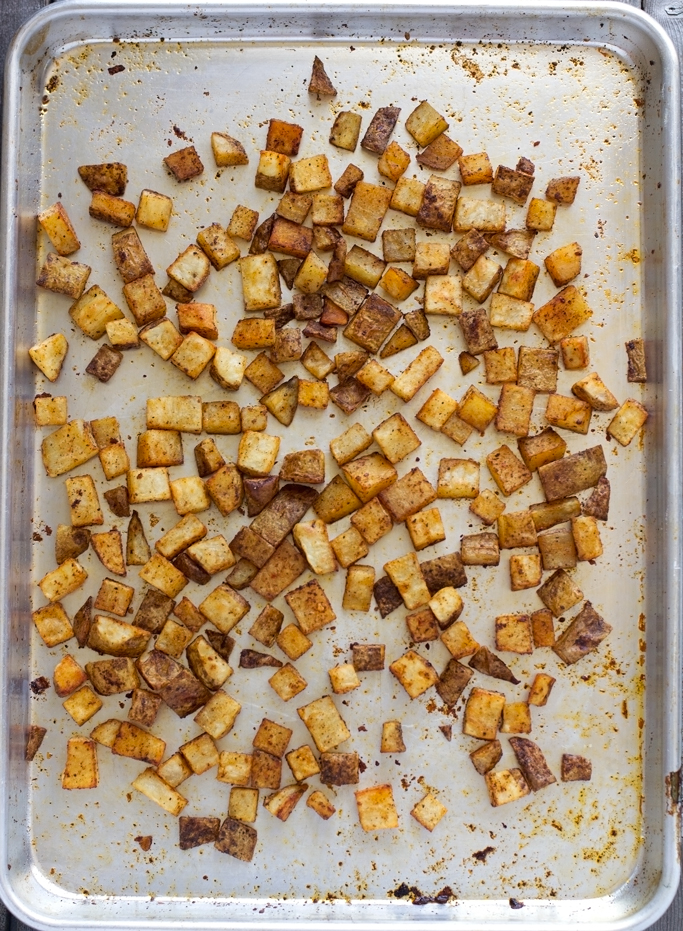 Cheesy Ranch Roasted Potatoes - Baked southwestern potato bites topped with a ranch greek yogurt sauce! #potatobites #potatowedges #vegetarian #greekyogurtsauce #ranchdressing | littlespicejar.com