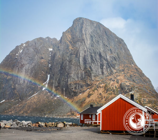 A rainbow in the Lofoten Islands, Norway, with a red fisherman cabin