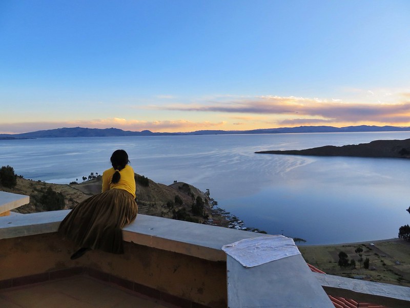 Bolivian girl watching the Lake Titicaca sunset