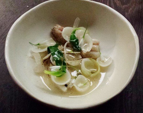 Butter poached skate wing, wild spring onion, ramps, onion flower, pickled capers, dashi
