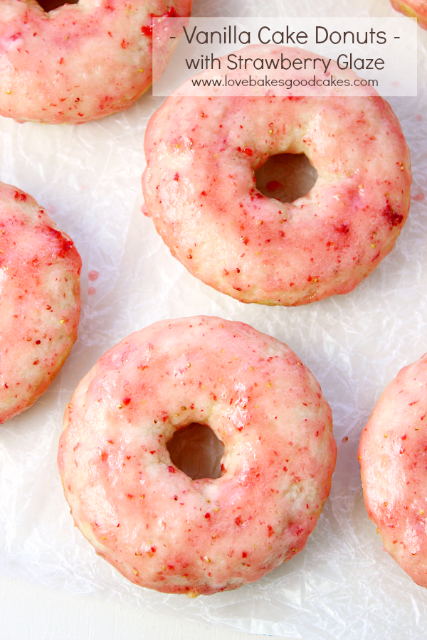 Vanilla Cake Donuts with Strawberry Glaze on a cookie sheet.