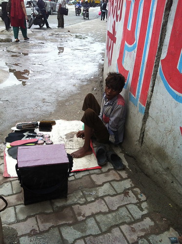 A young boy with sandal repair kit and cleaning supplies for shoes.