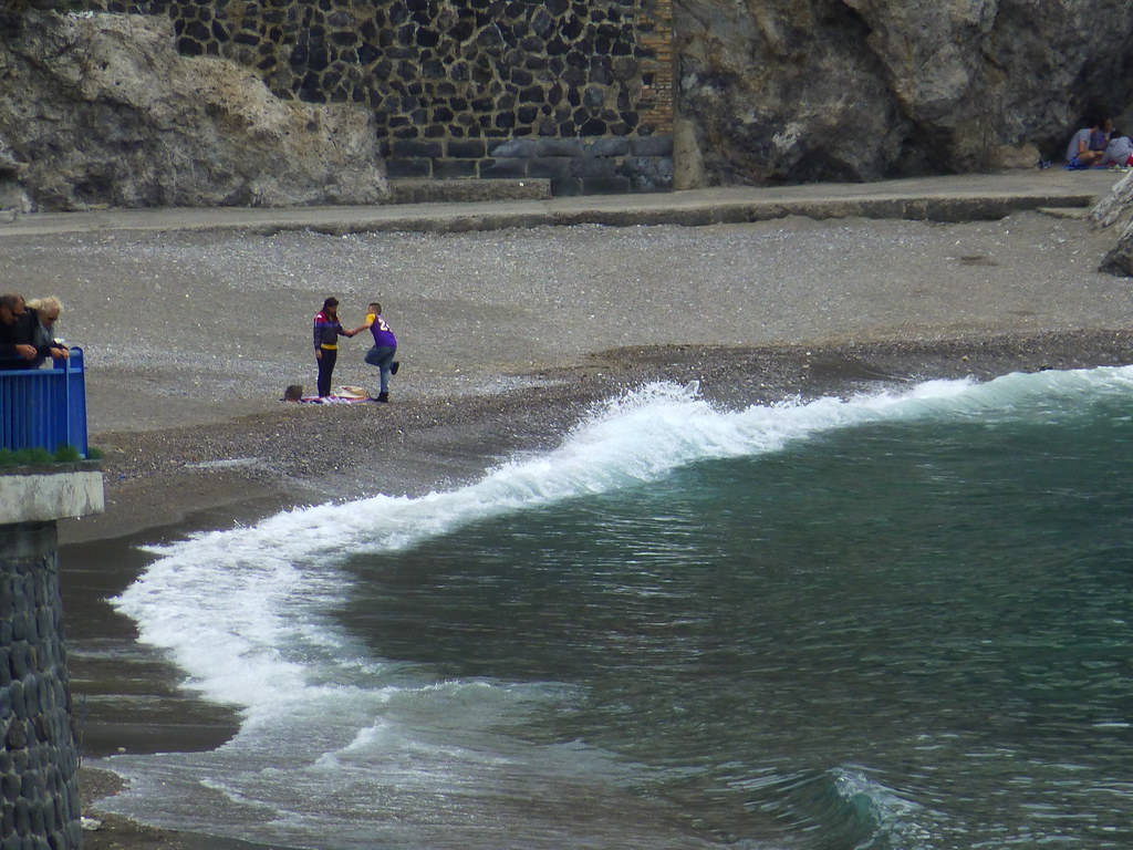 A couple enjoys the beach, despite the chilly weather.