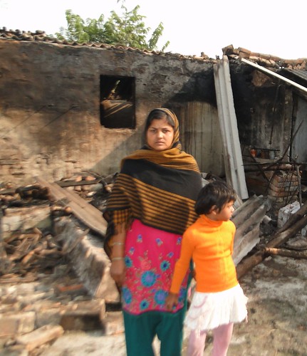 Saeeda Khatoon standing outside her burnt house in Azizpur village.