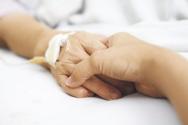 Daughter holding her mother hand in hospital from Flickr via Wylio
