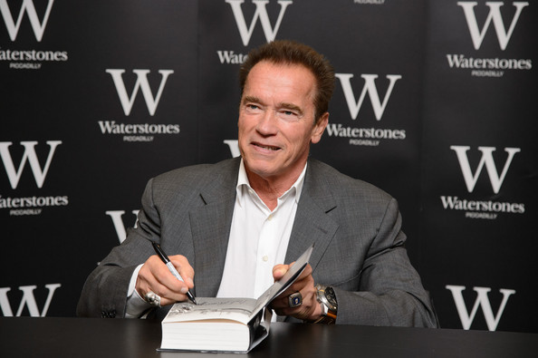 Arnold signing a copy of his book (picture via The Guardian)