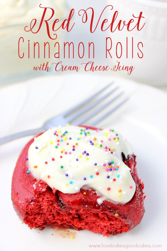 Red Velvet Cinnamon Rolls with Cream Cheese Icing on a plate with a fork.