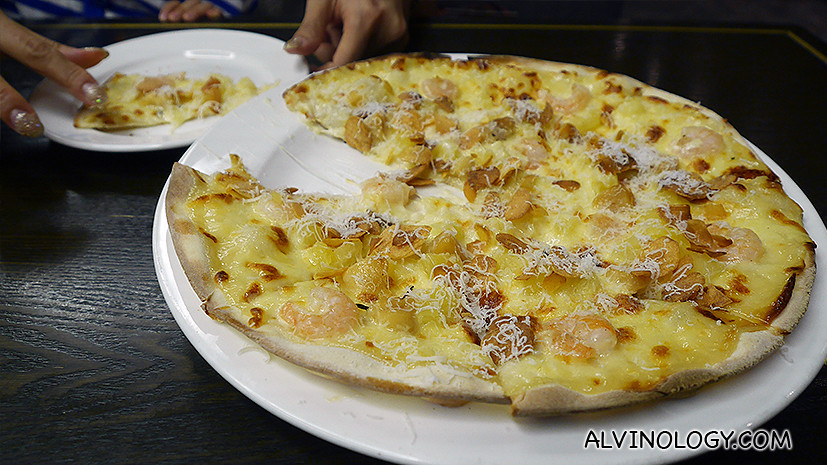 Garlic Snowing Pizza is topped with prawns, pineapple chunks, garlic flakes and type of mild cheese