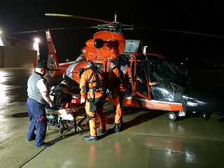 Crew members from Coast Guard Air Station Traverse City, Mich., transfer an ill man from an MH-65C Dolphin helicopter to emergency medical services at the air station, Nov. 23, 2014. The man was medically evacuated from Beaver Island in Lake Michigan due to suffering from signs of a stroke.  U.S. Coast Guard photo by Lt. Cmdr. Charlie Wilson.