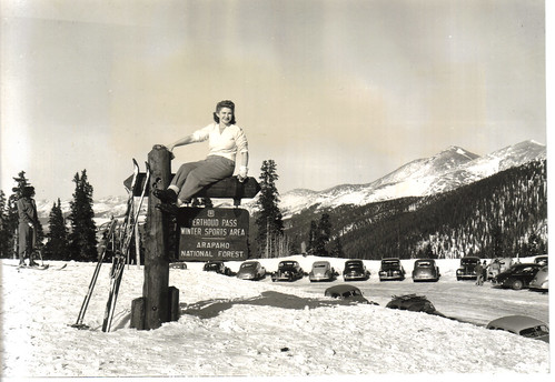 A woman poses atop a U.S. Forest Service sign after 5 feet of snow accumulated at Berthoud Pass Winter Sports Area on the Arapaho-Roosevelt National Forests. (U.S. Forest Service/Jay Higgins) 