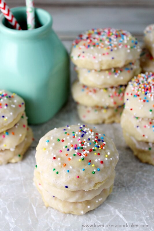 Italian Ricotta Cookies stacked up with a blue bottle. 