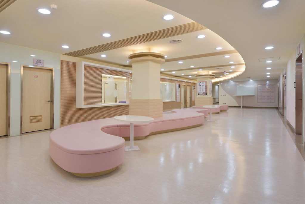 婦女醫美區的室內設計以粉色系為基底，搭配木質格柵及烤漆玻璃，希望給予病患明亮時尚的溫馨感受
