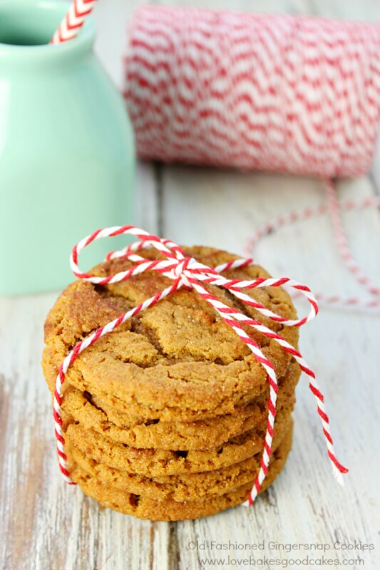Old-Fashioned Gingersnap Cookies stacked and tied up with a glass of a milk.