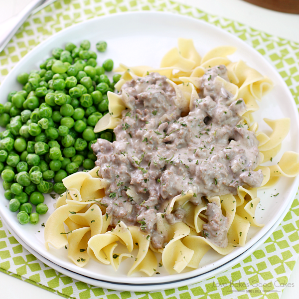 Hamburger Stroganoff on a white plate with green peas.,