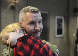 Petty Officer 2nd Class Bradley Walker, a tactical coxswain with Port Security Unit 308, holds his 16-month-old son, Anderson, before he boards a plane with the rest of his unit to deploy to Guantanamo Bay, Cuba, Jan. 5, 2015. Walker works as a law enforcement officer with the state of Mississippi when he's not drilling with PSU 308.  (U.S. Coast Guard photo by Petty Officer 3rd Class Jonathan Lally)