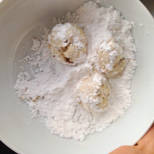 russian tea cookies getting rolled in powdered sugar