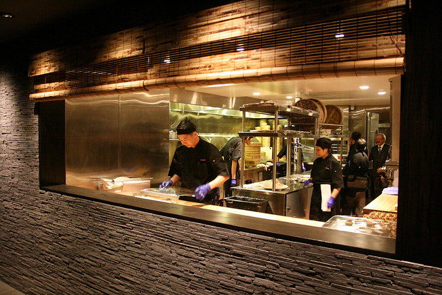 There are large windows that showcase the kitchen at work