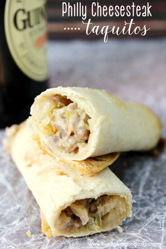 Philly Cheesesteak Taquitos stacked on top of one another with a bottle of Guiness beer.