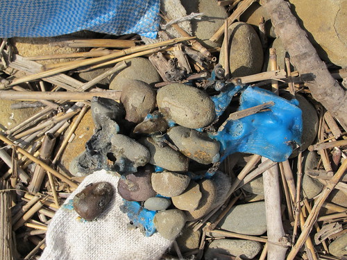 我在礫石堆中遇到這樣詭異的東西，彷彿在諷 刺人類與塑膠之間的關係。颱風後在海岸堆積的 垃圾，被相關單位放火燃燒，如此粗糙的處理方 式並沒有讓垃圾完全消失，許多燃燒後的塑膠殘 留物與海灘上的礫石，交錯黏結無法分離。