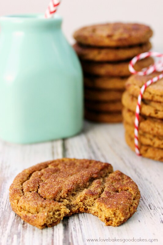 Old-Fashioned Gingersnap Cookies stacked and tied with a glass of milk.