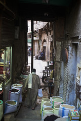 Egyptian man walking between spice shops in Khan el-Khalili Bazaar, Cairo, Egypt