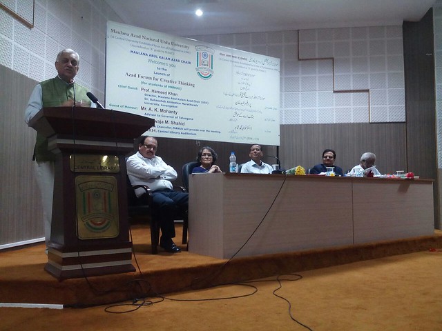 Dr. Khwaja M. Shahid delivering presidential remarks. Prof. Hameed Khan, Mr. A.K. Mohanty, Prof. S. A. Wahab, Prof. Amina Kishore and Mir Ayoob Ali Khan are also seen.