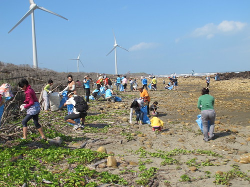志工在海岸四散開來分頭撿拾垃圾。