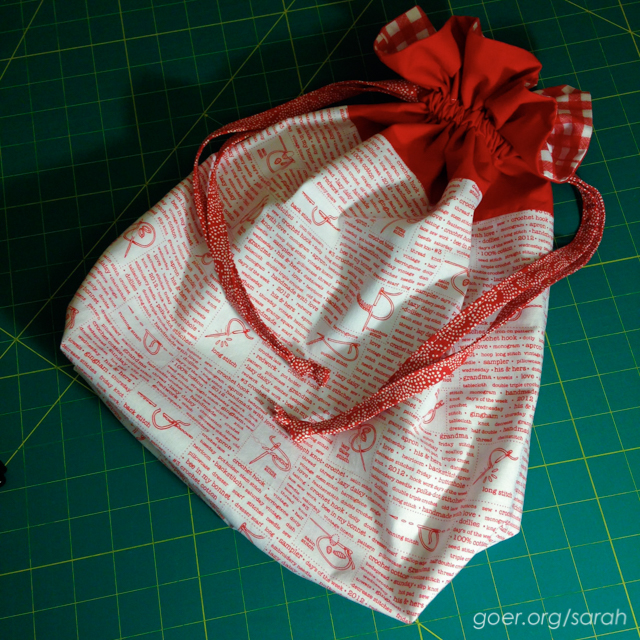 lined drawstring bag with red and white fabric featuring embroidery diagrams