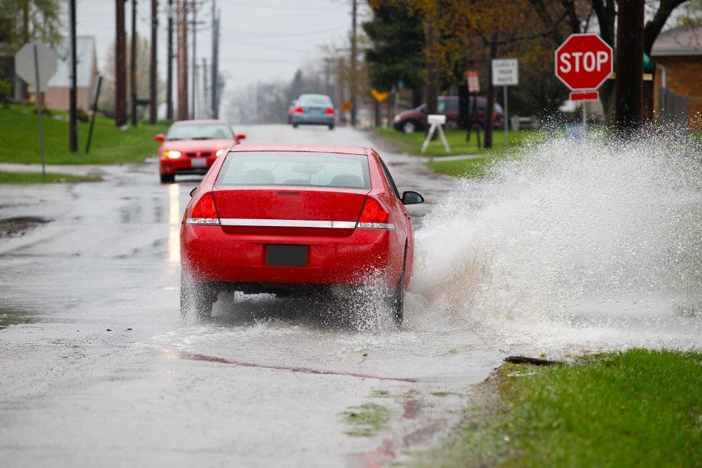 Car splashing through puddle on one side