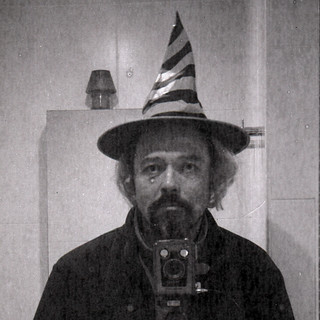 reflected self-portrait with Kodak Brownie SIX-20 Model F camera and pointed hat (square crop)