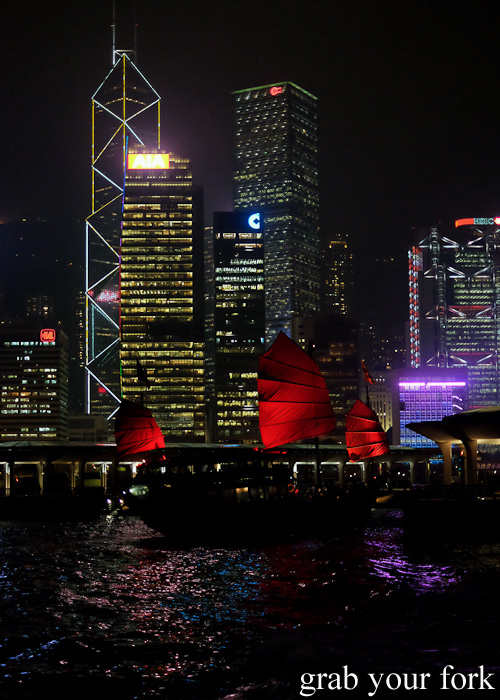Junk boat with red sails in Hong Kong harbour at night