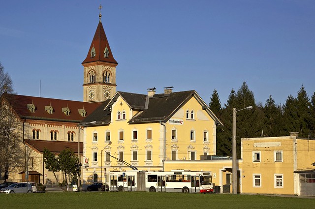 Hochflurgelenkbus 220, bis 2002 in Kapfenberg in der Steiermark im Einsatz, passiert die Itzlinger Pfarrkirche. Seit 2005 ergänzt das Fahrzeug den Wagenpark der Salzburg AG