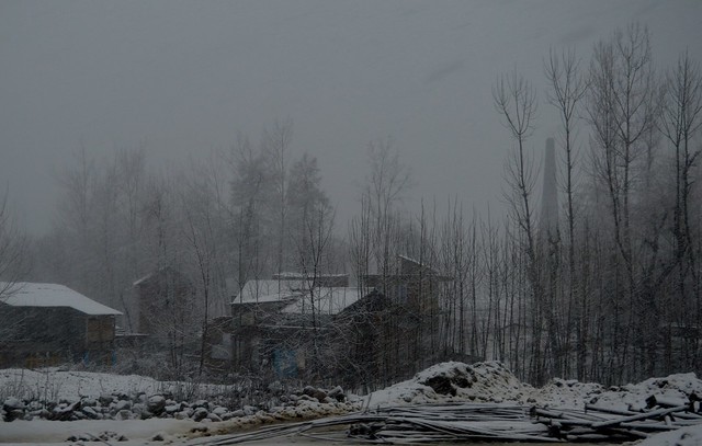 For days together scores of villages remain completely wrapped under dense fog. Houses stand still amid a blanket of snow, layer after layer, day after day amid tall sky-high defoliated trees. Here, a typical Kashmiri village near Qazigund.