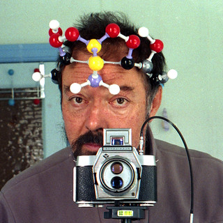 reflected self-portrait with Agfa Flexilette camera and molecular hat (square crop)