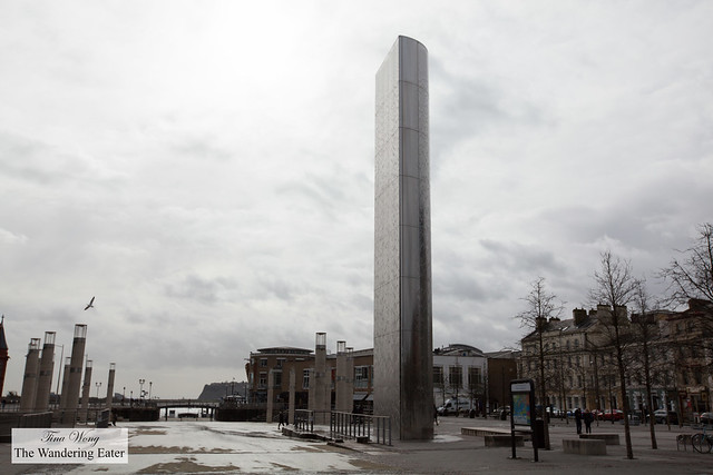 Moody gray skies with a tall stainless steel column with a water cascading down (it's a water feature)