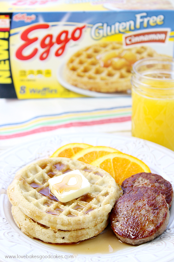 Sausage Egg & Waffle Breakfast with orange slices and a glass of orange juice.