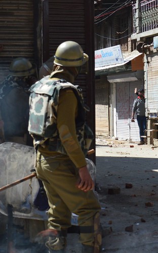 Face-off between an agitating stone-pelter and security forces.