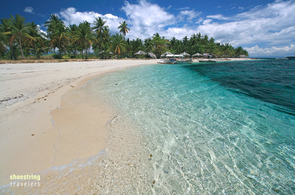 Digyo’s white sand beach, coconut palms and colorful crystalline waters