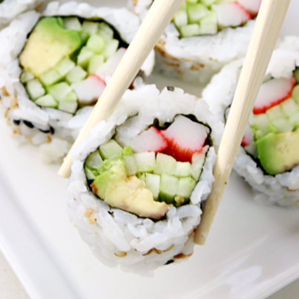 Close up of sushi with chop sticks.